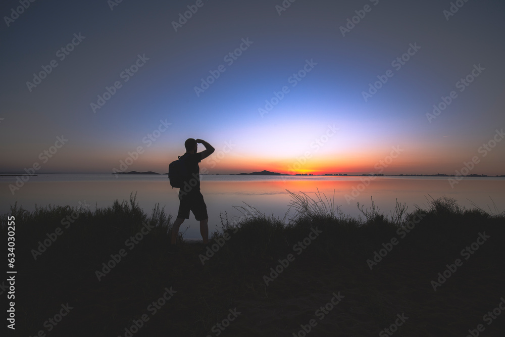 Silhouette of man watching the sunrise in the Mar Menor, Cartagena