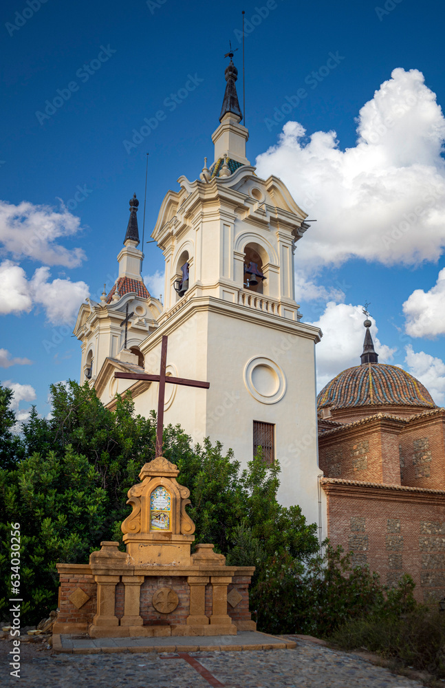 Vertical photo of the Sanctuary of La Fuensanta in Murcia, Spain, with a cross for religious worship in the foreground Vertical photo of the Sanctuary of La Fuensanta in Murcia, Spain, with a cross for religious worship in the foreground