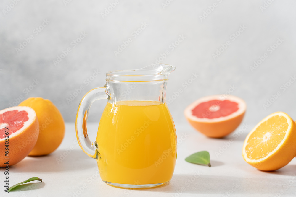 Orange juice in jur surrounded by citrus fruits. Detox, vitamin cocktail in bottles Orange juice in jur surrounded by citrus fruits. Detox, vitamin cocktail in bottles
