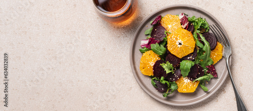 Seasonal vitamin salad orange beetroot and arugula in plate on light background. Diet, healthy eating concept