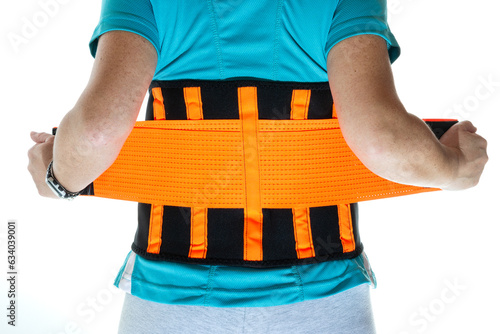 Back woman putting on a lumbar girdle to take weight and relieve pain. High quality photo