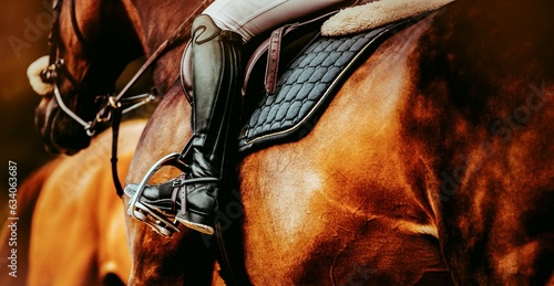Photos A high boot-clad rider's leg in a stirrup, mounted on a chestnut horse