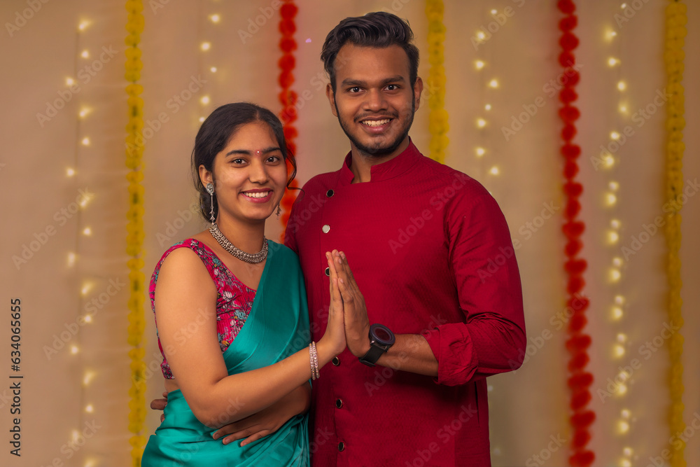 Indian couple wearing traditional dress and handshake during diwali