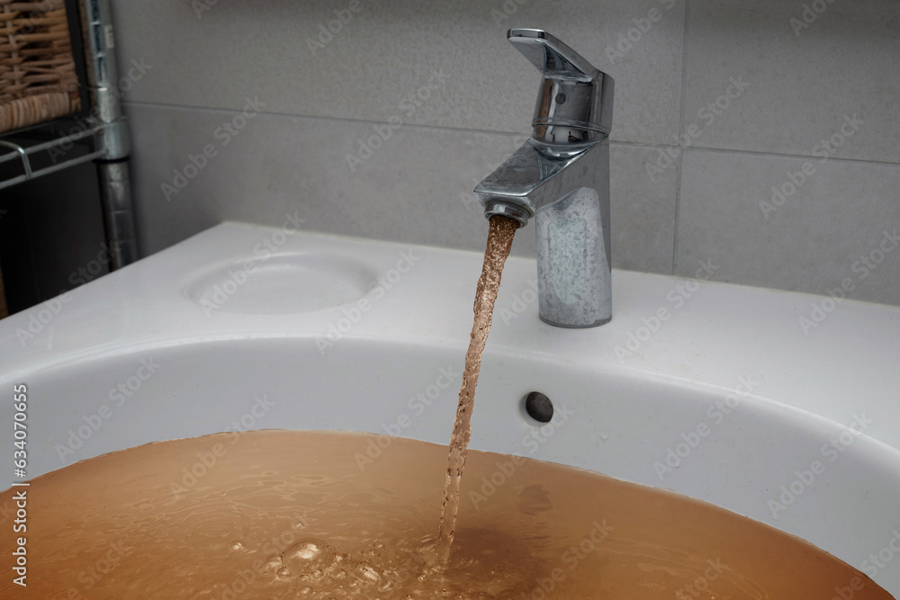 Dirty brown tap water after floods in the city streets after heavy rain