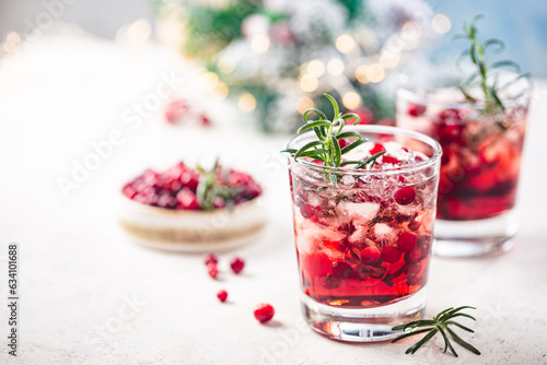 Refreshing drink with cranberries and rosemary on white background