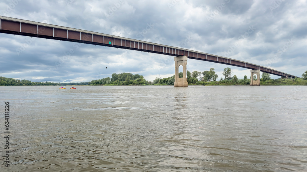 Naklejka premium two kayakers approaching a bridge over the Missouri River at Miami, MO