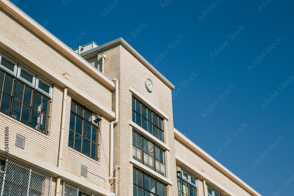 high school facade building with time clock in japan traditional classic style visible in cartoon anime manga high school facade building with time clock in japan traditional classic style visible in cartoon anime manga