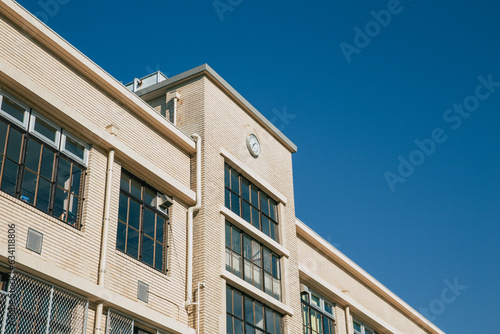 high school facade building with time clock in japan traditional classic style visible in cartoon anime manga © Quality Stock Arts