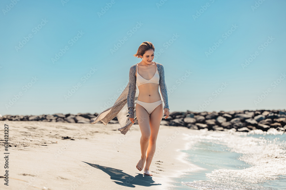 砂浜を歩く水着姿の日本人女性