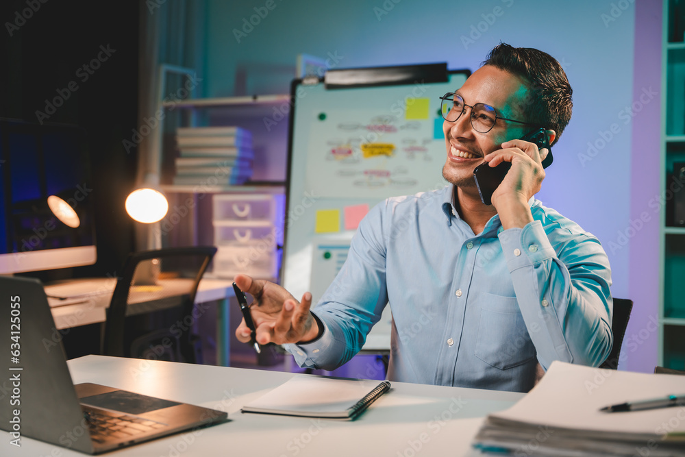 young man working at night Work comfortably on your smartphone. Social media chat at the office young man working at night Work comfortably on your smartphone. Social media chat at the office