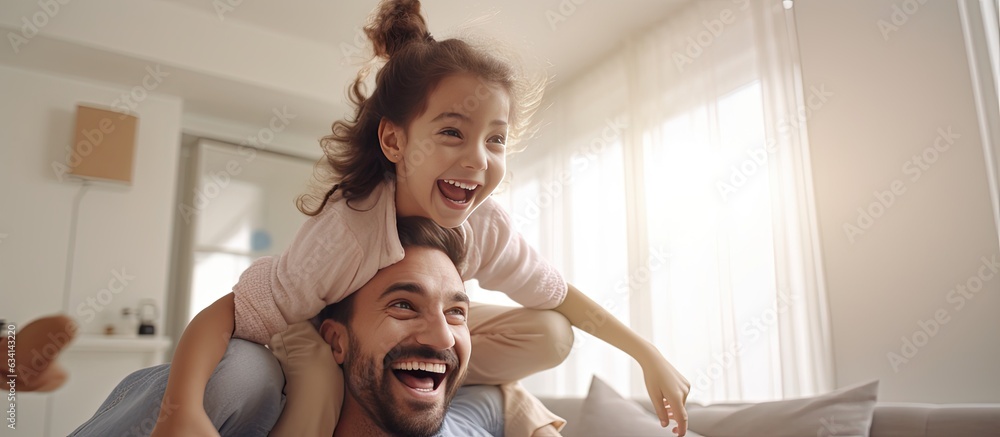 Middle eastern family playing together at home cheerful dad lifting up his joyful girl playing airplane copy space