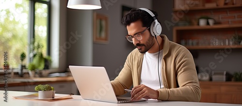 Indian man watching webinar at home Western man learning online photo