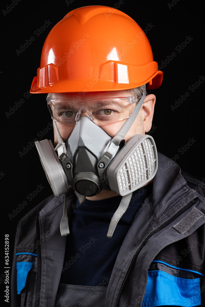 A man wearing a helmet, respirator and goggles on a black background A man wearing a helmet, respirator and goggles on a black background