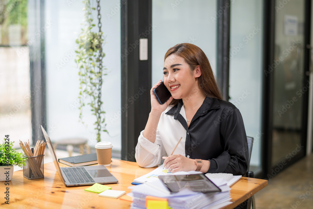 Young businesswoman using smartphone to call colleagues discussing project plans, Consult or teleconference Young businesswoman using smartphone to call colleagues discussing project plans, Consult or teleconference