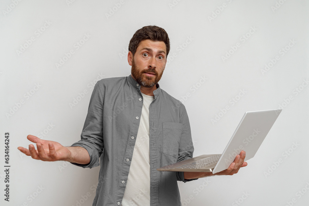 Man holding laptop and spreads his hands not knowing what to do on white background Man holding laptop and spreads his hands not knowing what to do on white background