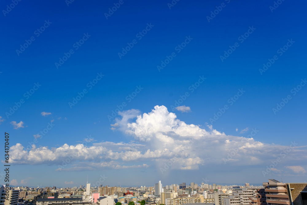 夏の昼間の空。真っ青な空に浮かぶ夏雲。神戸市内の高層ビル１５階より撮影