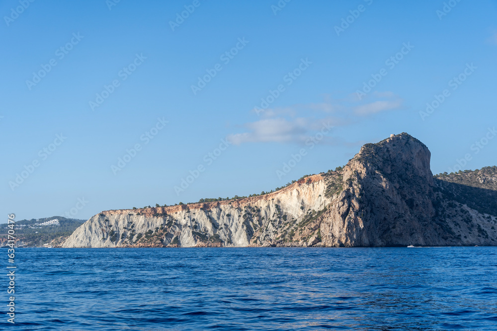 A rock perched over the blue sea of Ibiza