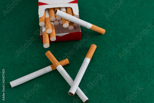 open pack of cigarettes standing isolated green