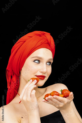 Fun woman with strawberry on the black background