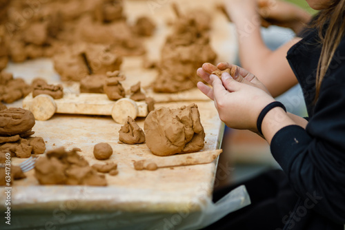 Childrens lesson for modeling from Natural terracotta clay piece held in hands. Wet clay material for sculpture or modeling