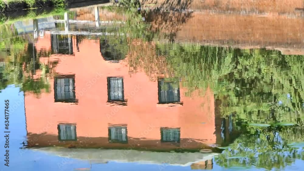 House and humpback bridge reflected in duck pond with passing van in Finchingfield, Essex, UK. House and humpback bridge reflected in duck pond with passing van in Finchingfield, Essex, UK.
