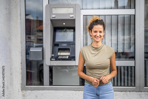 Portrait of adult caucasian woman stand in front of ATM machine © Miljan Živković
