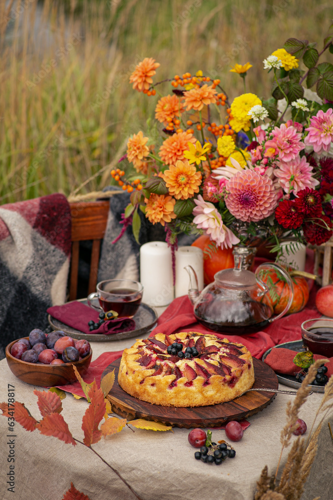 Fototapeta premium Thanksgiving dinner preparation. Table with pumpkin, autumn season pie. Decorated kitchen in Halloween season. Cooking celebration feast. Fall seasonal table.