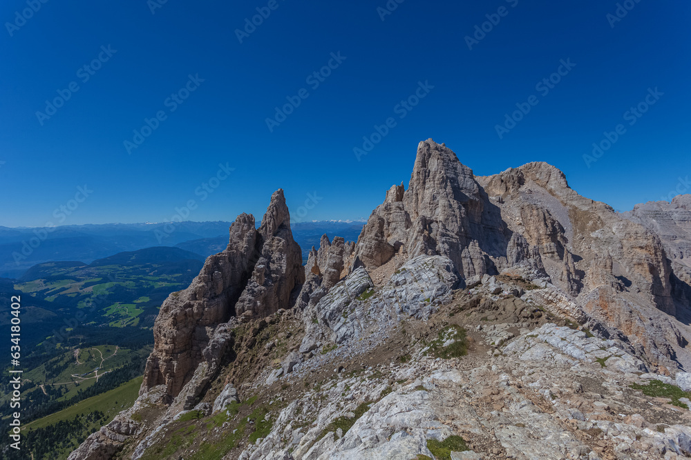 Awesome summer dolomite rocky panorama with innumerable spiers in the Latemar Massif, UNESCO world heritage site. The main pinnacle is named Torre di Pisa. Trentino-Alto Adige, Italy, Europe