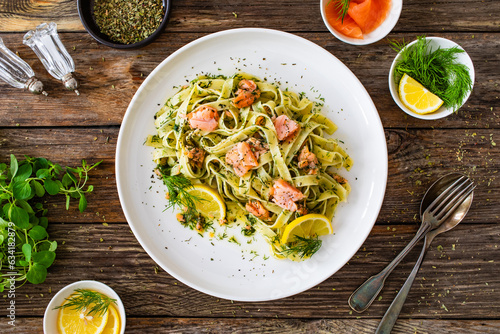 Tagliatelle with salmon and dill on wooden table 