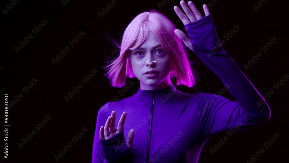 Woman in futuristic costume with flowing hair. Female in modern VR glasses interacting with network while having virtual reality experience. Augmented reality game, future technology, AI concept. VR. Woman in futuristic costume with flowing hair. Female in modern VR glasses interacting with network while having virtual reality experience. Augmented reality game, future technology, AI concept. VR.