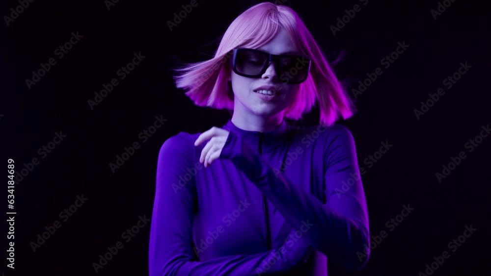 Beautiful woman in futuristic costume with flowing hair while touching air in neon lights. Augmented reality, game, future technology concept, VR, cinema. Beautiful woman in futuristic costume with flowing hair while touching air in neon lights. Augmented reality, game, future technology concept, VR, cinema.