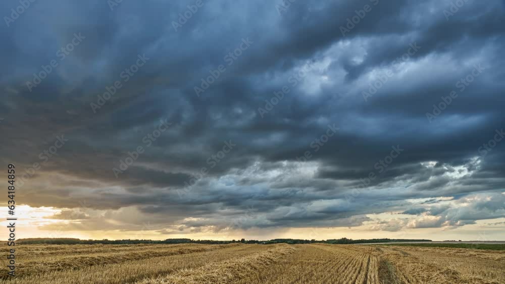 Movement of clouds during sunset over an agricultural field. A gray cloud with a thunderstorm and rain floats across the sky with a visible rain band. Heavy rain in the village. Timelapse clouds Movement of clouds during sunset over an agricultural field. A gray cloud with a thunderstorm and rain floats across the sky with a visible rain band. Heavy rain in the village. Timelapse clouds