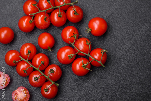 Delicious fresh cherry tomatoes on the branches as an ingredient for cooking a vegetarian dish