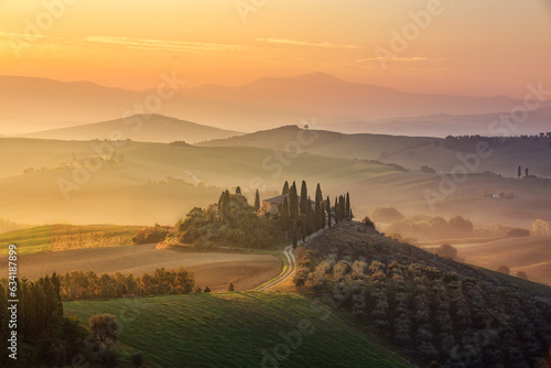beautiful land house in Tuscany Italy with beautiful golden sunset lighting up the haze in the background 