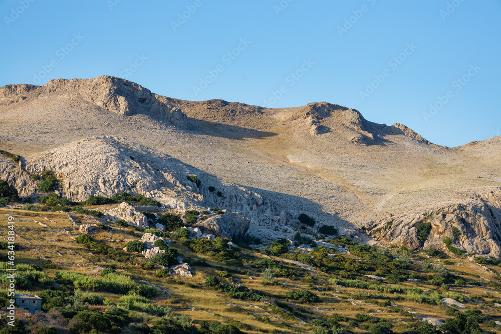 Colorful green landscape with rocks and hills in the background with sunset light. Alpine landscape in mountains, rocky mountains and green hills