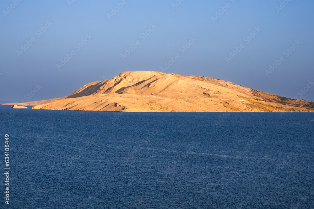 Sandy lonely island in the ocean, refreshed by the sun at sunset. Landscape photography of uninhabited islands
