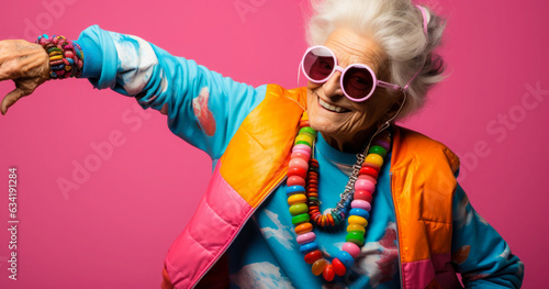 Senior Woman Fashion Model on Colored Background: A senior woman poses in front of a colored background, looking elegant and stylish. © Bartek