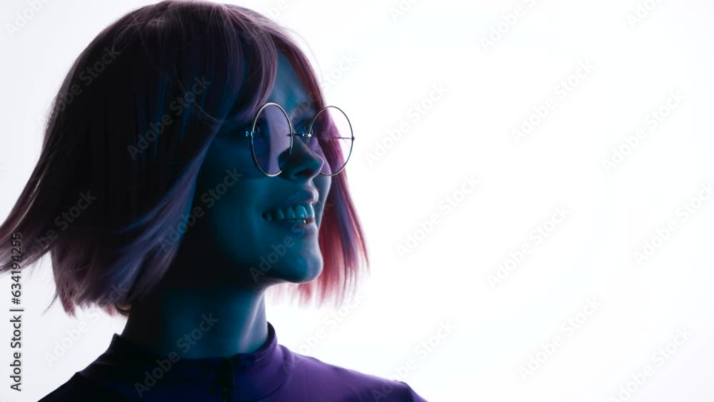 Beautiful woman with purple hair in futuristic costume over white background. Girl in glasses of virtual reality. Augmented reality, game, future technology, AI concept. VR. Blue, violet neon light. Beautiful woman with purple hair in futuristic costume over white background. Girl in glasses of virtual reality. Augmented reality, game, future technology, AI concept. VR. Blue, violet neon light.