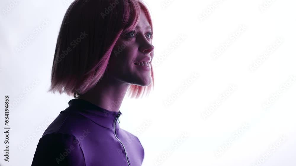 Beautiful woman with purple hair in futuristic costume over white background. Girl in glasses of virtual reality. Augmented reality, game, future technology, AI concept. VR. Blue, violet neon light. Beautiful woman with purple hair in futuristic costume over white background. Girl in glasses of virtual reality. Augmented reality, game, future technology, AI concept. VR. Blue, violet neon light.