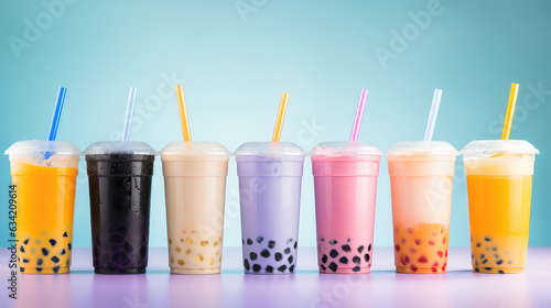 Commercial photography, variety of bobba bubble milk tea in transparent plastic cups standing in a line isolated on flat pastel background. photo