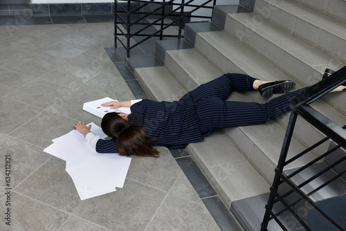 Fotografie, Obraz Unconscious woman with scattered folder and papers lying on floor after falling