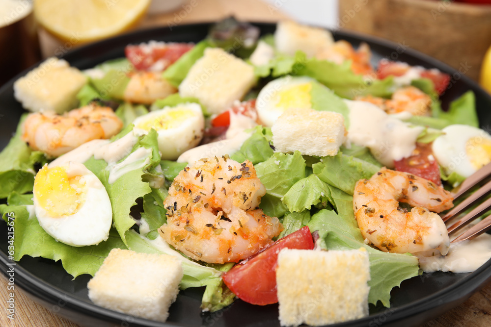 Delicious Caesar salad with shrimps on table, closeup