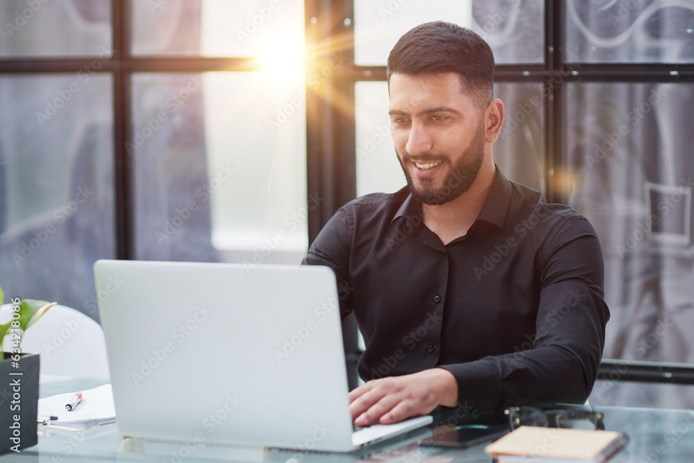 Fototapeta premium Middle-aged man working on laptop in office