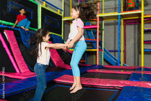 фотографія Little girls jumping in the trampoline area of the playroom