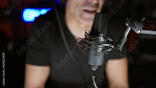 Young hispanic man speaking in a radio show at radio studio