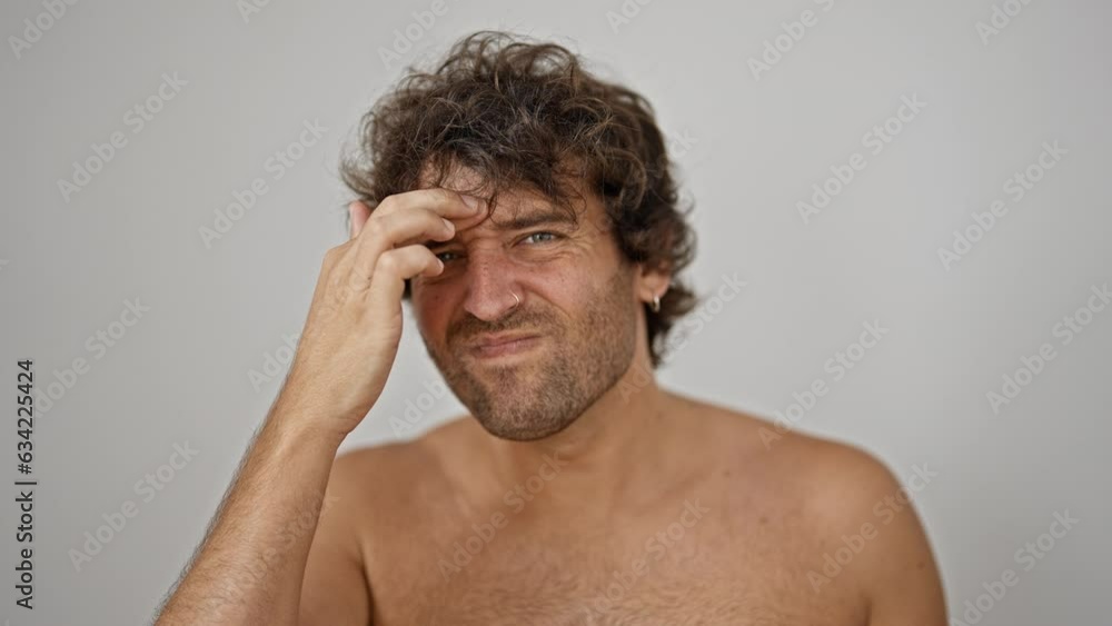 Young hispanic man touching dark circle and wrinkle over isolated white background Young hispanic man touching dark circle and wrinkle over isolated white background