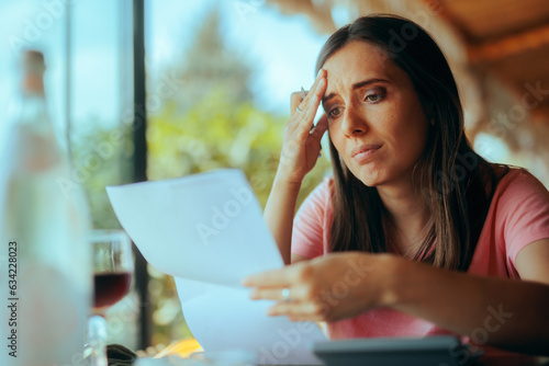 Stressed Yong Woman Trying to Calculate her Taxes. Unhappy girl trying to pay her loan recalculating her expenses 
 photo