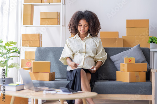 Small business entrepreneur SME freelance pregnant african woman work from home her hand holding credit card with box, online marketing packaging mail box and delivery, SME e-commerce concept © David
