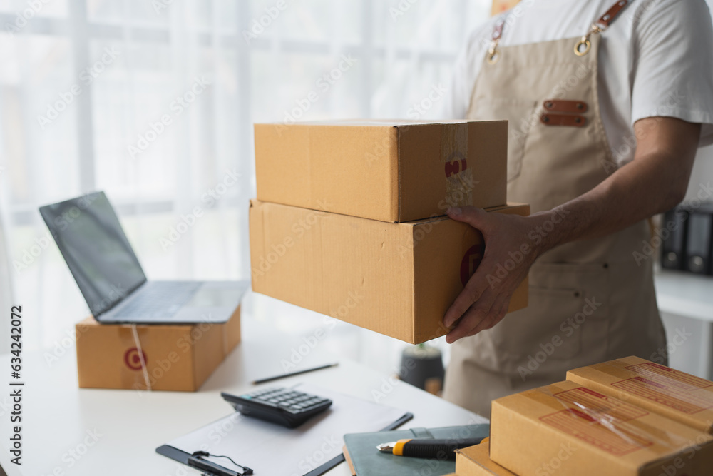 Small Business Startup Owner Asian Independent Entrepreneur Arranging multiple parcel boxes on online orders for delivery arrangements to customers, SME business concept. Small Business Startup Owner Asian Independent Entrepreneur Arranging multiple parcel boxes on online orders for delivery arrangements to customers, SME business concept.