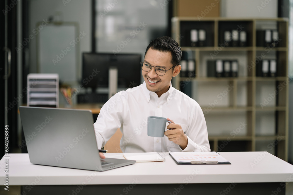 Businessman working with documents sitting at desk using laptop and smartphone at work. Businessman working with documents sitting at desk using laptop and smartphone at work.